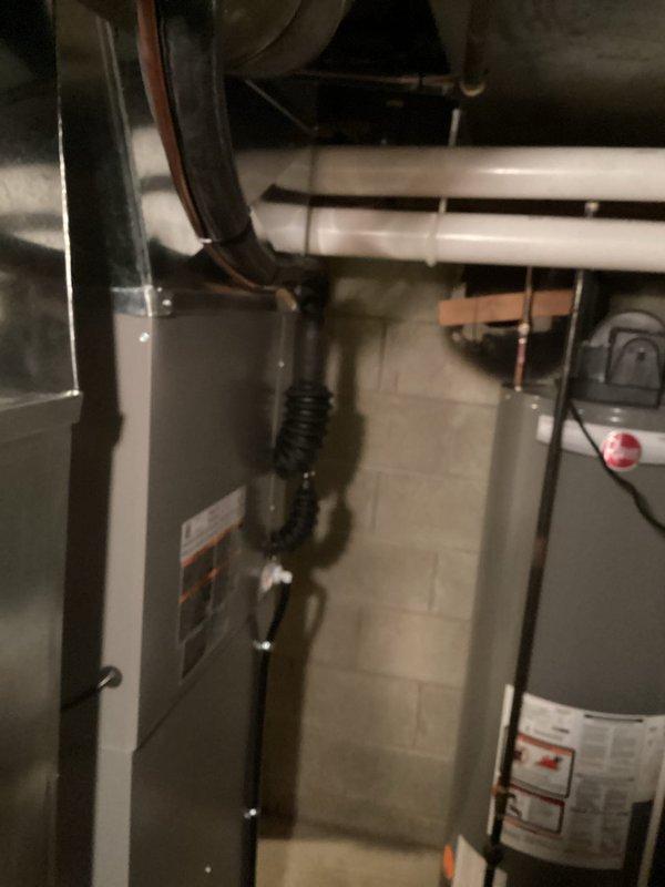 Completed installation of new air conditioning system and evaporator coil at residential property. New A/C condenser unit was positioned and secured at exterior location with proper refrigerant line sets, electrical connections, and condensate drainage routed through exterior wall penetration. Indoor evaporator coil was installed and integrated with existing furnace system in basement utility area, with all copper refrigerant lines properly insulated and secured throughout the installation path. System was charged to manufacturer specifications, tested for proper operation, and verified for adequate airflow and temperature differential.