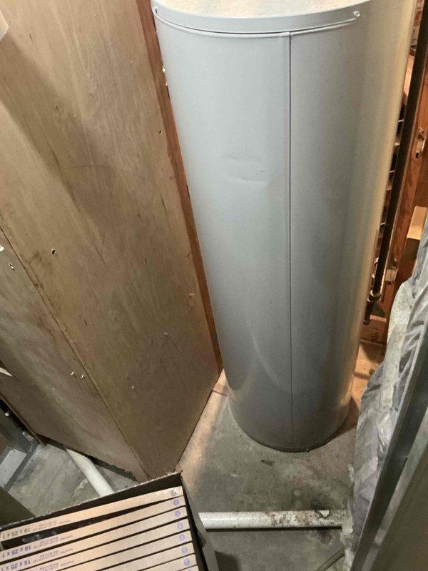 Completed comprehensive HVAC system evaluation in basement utility area for equipment replacement estimate. Assessed existing infrastructure including ductwork configuration, available clearances around current water heater installation, and spatial requirements for new HVAC equipment placement. Documented current mechanical room layout with exposed ceiling joists, PVC drainage lines, and metal ductwork components to determine optimal positioning for replacement system and ensure proper clearances meet code requirements.