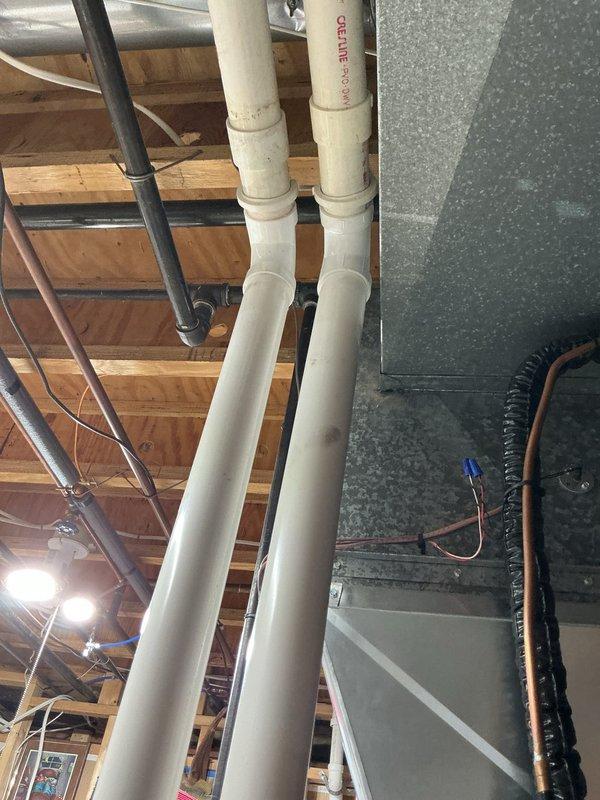 Completed comprehensive HVAC tune-up service on residential air handler system located in basement utility area. Performed standard maintenance procedures including inspection of refrigerant lines, ductwork connections, condensate drainage system, and electrical components. All mechanical systems were found operating within normal parameters, with PVC drainage lines and copper refrigerant tubing showing proper installation and no visible defects.