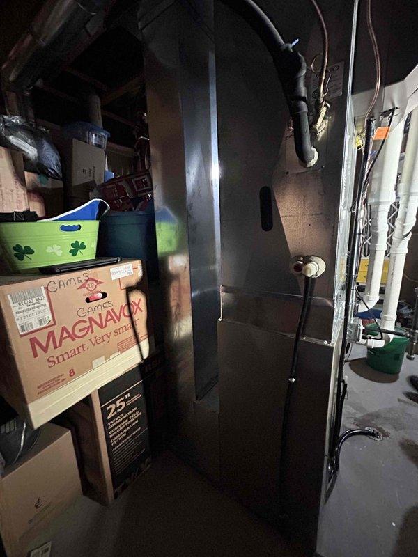 Completed installation of Carrier furnace unit (Model: SBLRMAM02MUN1Y11G, Serial: 5M2535L955) in basement utility area. Unit was positioned and secured with proper clearances maintained from stored items and existing HVAC ductwork, all electrical connections completed, and system tested for proper operation.