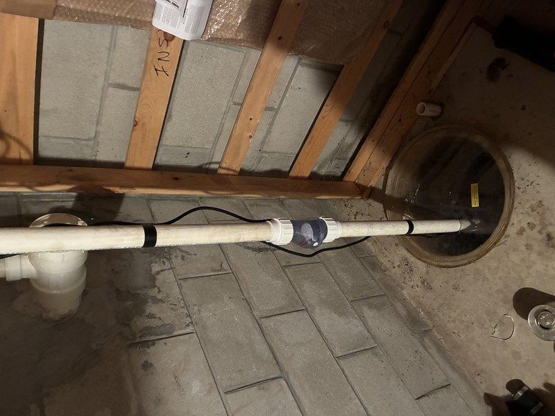 Completed installation of sump pump system in basement utility area, including proper basin placement, discharge piping with PVC components and appropriate fittings, and electrical connections. Verified float switch operation and tested pump functionality to ensure proper water removal and automatic cycling. System is now operational and ready to protect the basement from water accumulation.