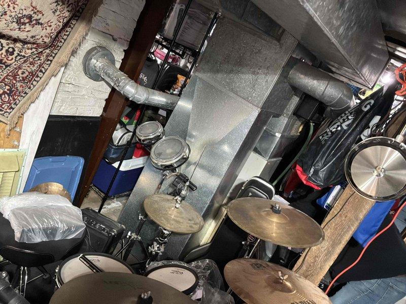 Completed comprehensive HVAC system evaluation in residential basement utility space for furnace replacement estimate. Assessed existing gray metal furnace unit with exposed access panel, documented current ductwork configuration including large metallic supply ducts extending from unit across ceiling, and evaluated spatial constraints for new equipment installation given storage items and recreational equipment in surrounding area. Photographed existing system layout and mechanical components to provide accurate replacement specifications and ensure proper sizing for new high-efficiency heating system.