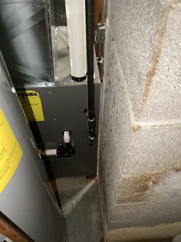 Completed installation of new HVAC furnace unit in utility space with proper venting and drainage configuration. Installed gray metal furnace cabinet with associated ductwork connections, secured white PVC condensate drain and vent piping with appropriate mounting brackets, and completed all electrical connections to manufacturer specifications. System tested and verified operational upon completion.