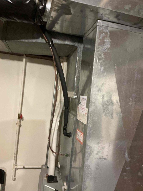 Completed comprehensive HVAC system assessment and duct cleaning estimate for vertical air handler unit located in mechanical room. Inspected galvanized metal ductwork and air handler showing surface moisture condensation, oxidation patterns, and operational wear typical of aging systems. Documented existing conditions including copper refrigerant lines, electrical connections, and mounted control panel to provide accurate scope of work for proposed duct cleaning services and system maintenance recommendations.