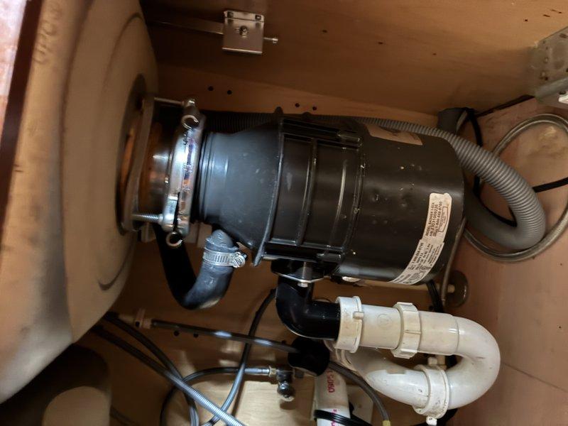 Completed comprehensive plumbing inspection of residential kitchen and basement utility systems. Examined under-sink garbage disposal installation, verifying proper mounting, electrical connections, and PVC drain configuration, as well as basement water supply system including main distribution lines, shut-off valves, and mechanical equipment connections. All components found to be properly installed and functioning within normal parameters.