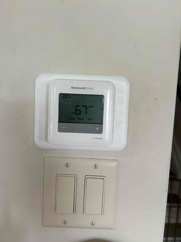 Completed installation of new HVAC furnace system in residential basement utility area. Installed vertical furnace unit with metallic ductwork, connected black flexible supply ducts to upper plenum, and integrated system with existing ductwork infrastructure. Mounted and programmed Honeywell Home ProSeries digital thermostat on main level, configured heating and humidity control settings, and verified proper communication between thermostat and furnace unit for optimal system operation and temperature regulation.