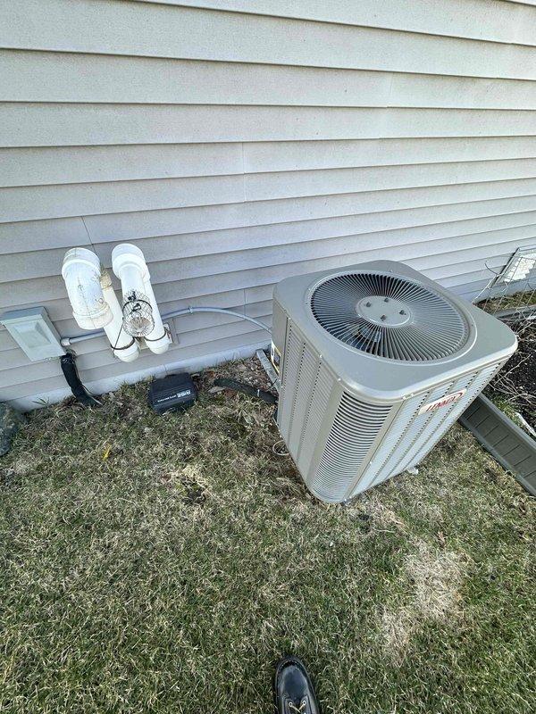 Completed full HVAC system replacement including installation of new high-efficiency furnace in basement mechanical room and matching outdoor condensing unit. Furnace was positioned on existing concrete pad with proper clearances, connected to white PVC venting system for intake and exhaust, and integrated with existing ductwork distribution system. Outdoor condensing unit was set on level concrete pad with appropriate drainage, electrical disconnect box mounted to exterior wall with PVC conduit for line set protection, and all refrigerant lines properly insulated and secured. System was pressure tested, evacuated, charged to manufacturer specifications, and cycled through multiple heating and cooling operations to verify proper function of all components including blower motor, compressor, and safety controls.