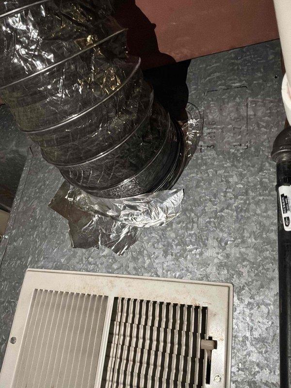 Completed HVAC system replacement in residential basement utility area. Installed new air handler unit with associated ductwork, condensate drainage system utilizing white PVC piping with proper fittings and elbows, and electrical connections including control box mounting. Configured flexible aluminum ductwork to floor register for proper air distribution throughout the residence.