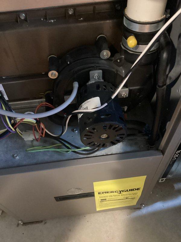 # HVAC Furnace Inspection and Maintenance

Performed comprehensive inspection and maintenance service on residential gas furnace system. Removed front access panel to evaluate internal components including blower motor assembly, gas burners, ignition system, and electrical connections. Inspected black circular blower motor mounted within cabinet, verifying secure mounting bolts and examining cooling vents for proper airflow. Checked all electrical wiring connections including red, white, and green conductor terminations to motor and control board.

Examined PVC condensate drain lines and venting system for proper installation and drainage. Verified yellow capacitor functionality and connections. Inspected gas burner assembly, ignition components, and flame sensing mechanisms for proper operation. Evaluated all safety controls and limit switches. Confirmed EnergyGuide label present and system specifications. All components found operating within normal parameters. System tested and retu