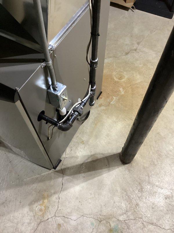 Completed furnace installation in basement utility area, including proper placement of HVAC unit, connection of refrigerant lines with insulation, and installation of associated piping and ductwork. All components were secured to concrete foundation, with door closer mechanism installed on utility room access door to ensure proper ventilation control and code compliance.