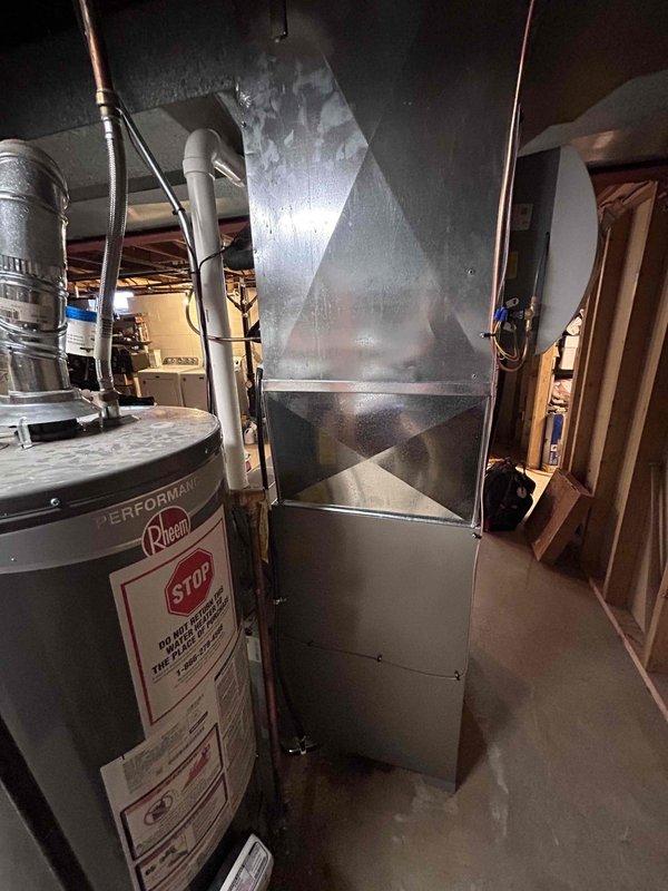 # HVAC Furnace Installation

Completed residential furnace installation in basement utility area. Installed new heating system with integrated ductwork assembly featuring galvanized sheet metal pentagonal trunk line for optimal airflow distribution. Connected copper refrigerant lines and configured system alongside existing Rheem water heater. Performed comprehensive system pressure testing using digital manifold gauge, verifying proper refrigerant pressures at 130 PSI on both high and low side ports to ensure system operates within manufacturer specifications. All mechanical connections secured, ductwork properly sealed, and system commissioned for reliable operation.