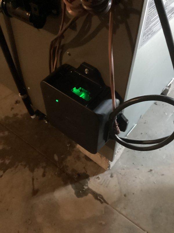 Completed prepaid HVAC maintenance visit on residential heating and cooling system. Performed comprehensive inspection of furnace unit with access panel removed, verifying proper operation of blower motor assembly, examining electrical connections and wiring integrity throughout the system, and checking heating elements and sensors for proper function. Inspected control board and diagnostic panel mounted on exterior cabinet for any error codes or operational issues.

Evaluated condensate pump system operation, confirming green indicator light showed active status and proper electrical supply. Examined copper refrigerant line connections running to condensate pump, verifying secure fittings and absence of refrigerant leaks. Noted minor water staining on concrete floor around pump base consistent with normal condensate drainage patterns. All components found operating within normal parameters with no immediate service concerns identified during this scheduled maintenance inspection.