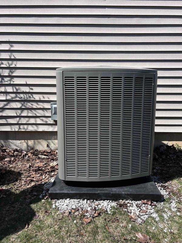 Completed installation of new air conditioning condenser unit and evaporator coil at residential property. Positioned outdoor condenser on concrete pad against exterior wall with proper clearances, installed condensate drain safety switch with wiring routed through metal plenum, and verified all electrical connections and refrigerant lines are secure and operational.