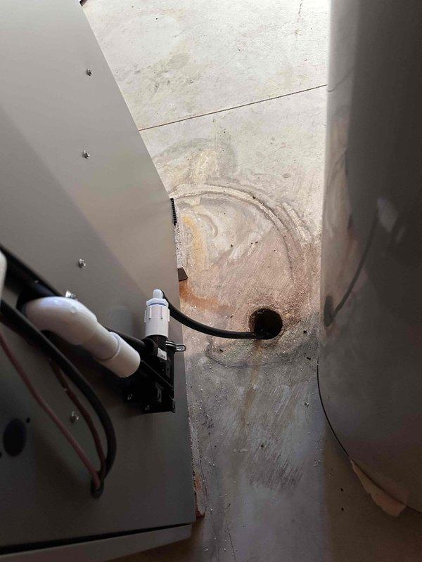 Completed installation of new air conditioning condenser unit and evaporator coil at residential property. Positioned outdoor condenser on concrete pad against exterior wall with proper clearances, installed condensate drain safety switch with wiring routed through metal plenum, and verified all electrical connections and refrigerant lines are secure and operational.