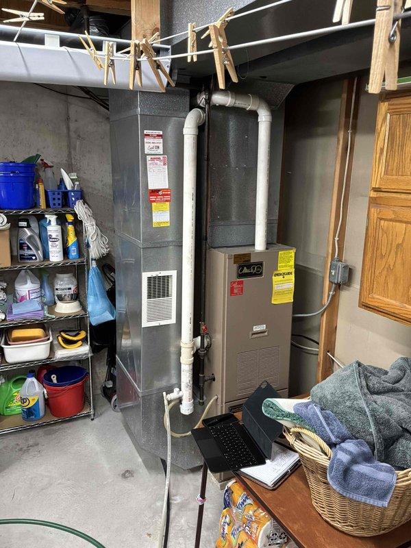 Completed comprehensive HVAC system evaluation in basement utility area for full equipment replacement estimate. Assessed existing furnace and water heater configuration, documented current installation including all PVC venting, condensate drainage systems, and clearance requirements for replacement unit specifications.