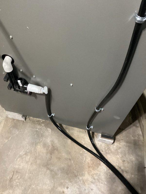 Completed installation of new Lennox high-efficiency furnace in basement location. Installed unit on concrete pad with proper leveling, connected white PVC intake and exhaust venting vertically through structure, and secured black flexible condensate drain lines to underside of equipment with metal clamps and white plastic fittings for proper drainage. Verified all connections, tested system operation, and ensured compliance with manufacturer specifications.