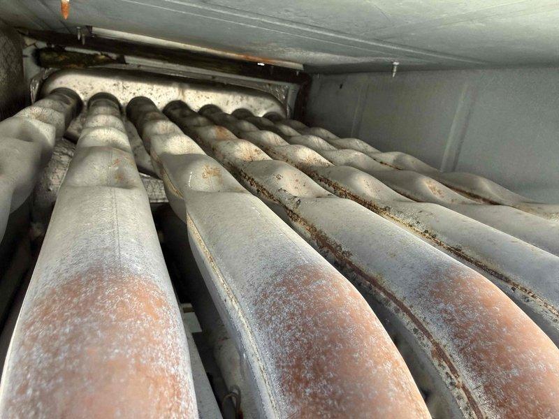 Performed comprehensive inspection of commercial furnace system revealing significant deterioration and operational concerns. Documented extensive rust staining on interior panels and heat exchanger components, along with severe frost and ice accumulation on burner tubes indicating potential combustion issues or heat exchanger failure. The heavy frost buildup combined with underlying corrosion suggests compromised system integrity requiring immediate attention to prevent safety hazards and system failure.