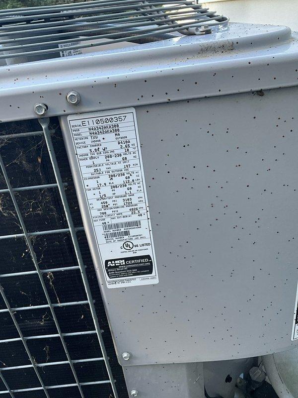 Completed HVAC estimate for replacement of existing outdoor air conditioning system. Assessed current cylindrical condenser unit with protective metal grille installed on concrete pad with proper electrical disconnect and conduit configuration. Evaluated equipment specifications including model E110500357, verified UL and AHRI certifications, and documented existing installation conditions including landscaping clearances, stepping stone access path, and proper unit positioning on level concrete pad for adequate drainage and stability.