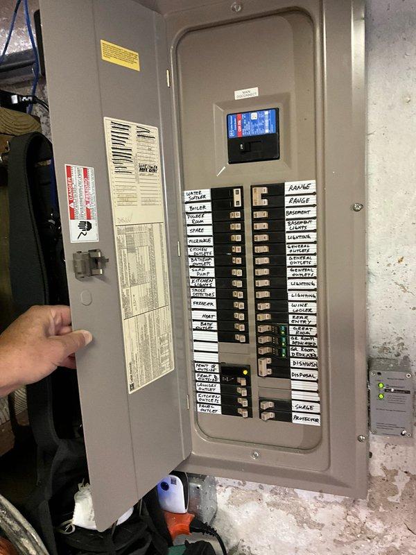 Conducted site assessment for mini split installation in upper-floor bedroom with sloped attic ceilings. Evaluated existing electrical panel capacity and circuit availability in basement utility area to determine compatibility for new mini split system power requirements. Photographed electrical infrastructure including main breaker panel with digital monitoring display and documented bedroom layout, including ceiling configuration, to develop installation plan and equipment placement recommendations for optimal heating and cooling efficiency.