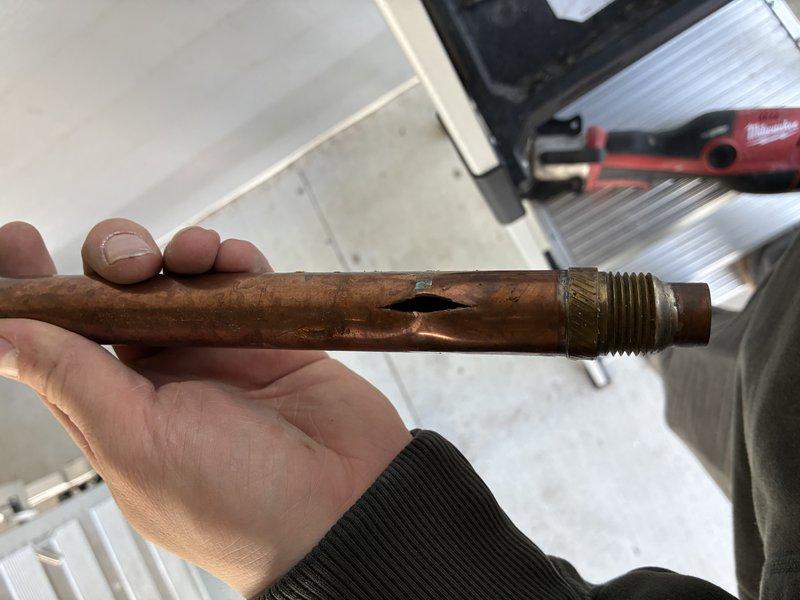 # Outdoor Spigot Pipe Replacement

Replaced severely corroded copper pipe serving outdoor spigot system. The existing pipe had failed due to extensive corrosion and perforation, causing water leakage. Removed damaged section with corroded brass fittings and installed new copper piping with proper connections to existing basement plumbing infrastructure. Installed shut-off valve for future maintenance access. System tested and confirmed operational with no leaks.