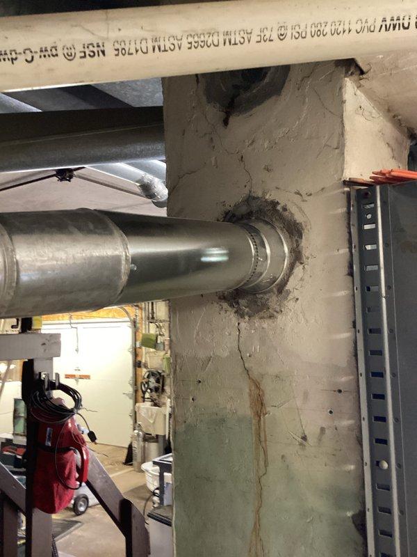 Completed furnace installation in basement utility area. New system includes properly sized supply and return ductwork with insulated flexible ducting connected to metal plenum. All vent piping installed to code specifications with appropriate PVC materials for condensate drainage and exhaust venting through exterior wall penetration.