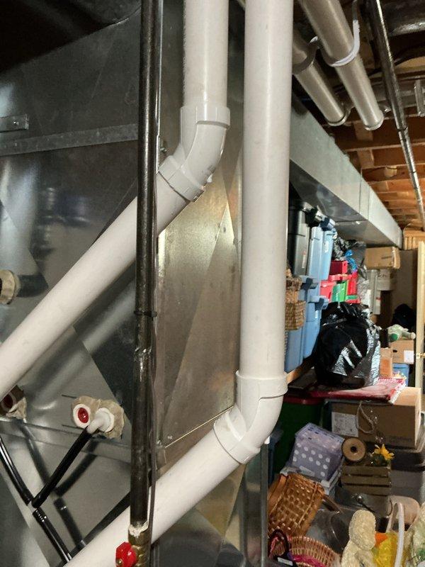 Completed prepaid HVAC maintenance visit and performed system inspection. Examined condensate drain assembly components including PVC piping, drain line connections, and associated hardware. Verified proper installation and functionality of drain system with elbow joints and vertical piping sections. Inspected HVAC unit housing, ductwork, and mechanical controls including valve mechanisms. System found to be operating within normal parameters with all components properly secured and functioning as designed.