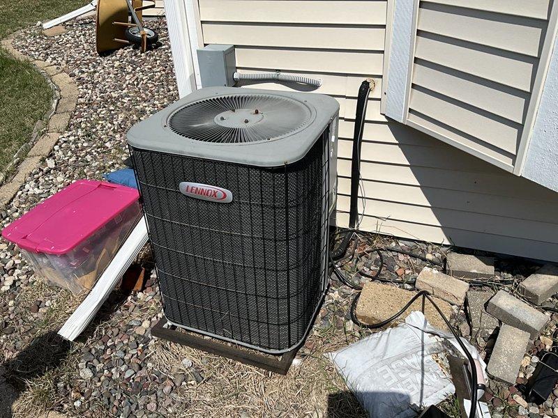 Completed HVAC system replacement including installation of new Lennox outdoor condensing unit positioned on concrete pad with updated landscaping clearance. Interior components include new air handler with integrated Honeywell humidifier system, metallic ductwork with flexible connections, condensate drain piping, and associated electrical controls mounted in utility closet. All equipment installed per manufacturer specifications with proper airflow configuration and drainage connections.