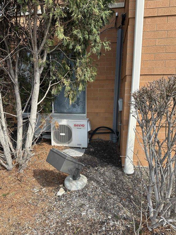 Completed commercial HVAC estimate for mini-split system installation in equipment room with existing data infrastructure and cable management systems. Assessed exterior wall-mounted Sanyo condenser unit and interior mounting requirements, evaluating electrical conduit routing, refrigerant line placement, and condensate drainage integration with existing building systems.