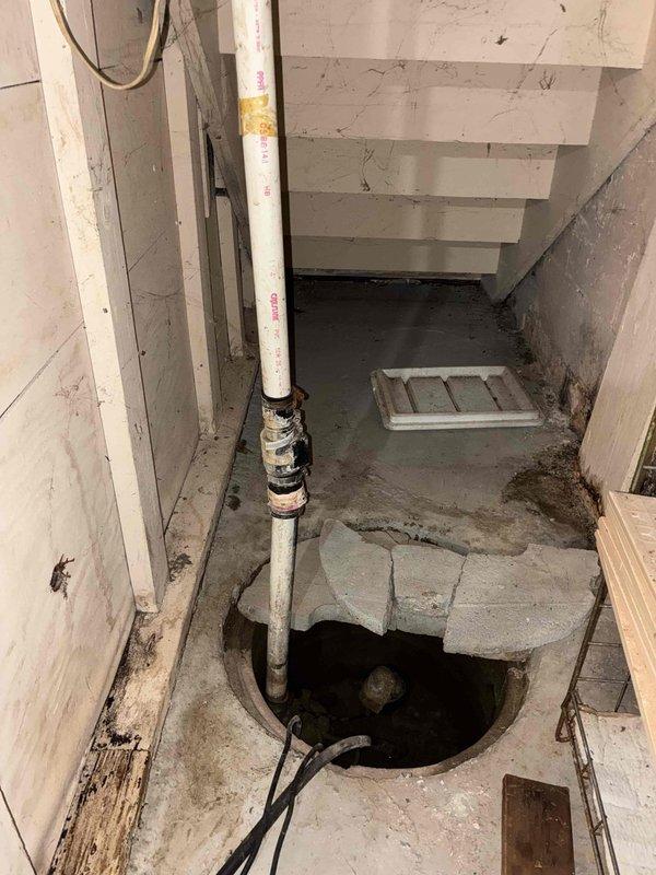 # Sump Pump Installation

Installed new sump pump system in existing concrete basin located in basement crawl space. The installation included connecting the pump to the existing vertical PVC discharge piping, securing all electrical connections and float mechanisms, and testing system operation to ensure proper water removal functionality. The pump was positioned in the deteriorated concrete pit with standing water, addressing the property's groundwater management needs.