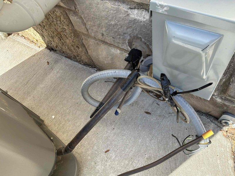 Completed full HVAC system replacement at residential property. Removed existing outdoor condensing unit and installed new air conditioning system on concrete pad adjacent to exterior wall. Routed refrigerant lines along building exterior using gray insulated copper piping with proper foam insulation, secured electrical disconnect box, and connected all necessary electrical wiring and communication cables. System installation included proper line set configuration, refrigerant charging, and verification of all connections to ensure optimal performance and compliance with manufacturer specifications.