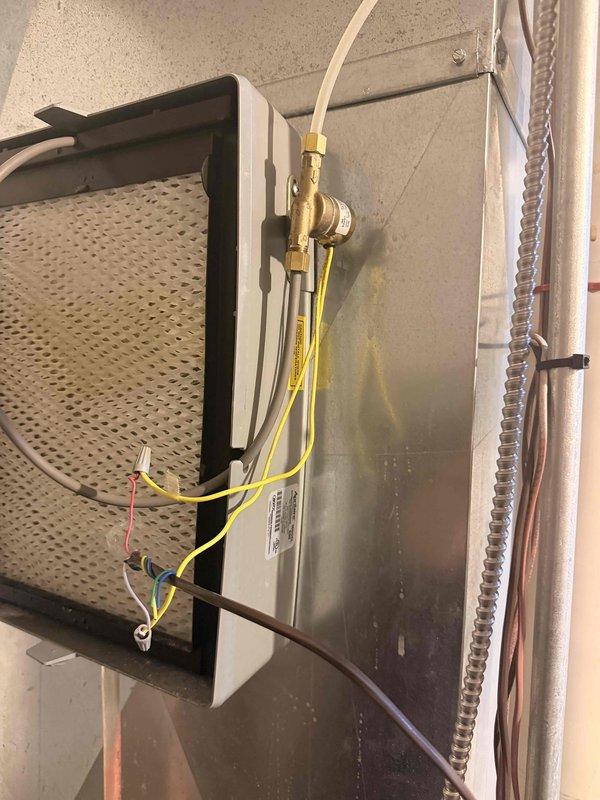Performed indoor air quality inspection and maintenance on residential HVAC air handler system. Inspected evaporator coil assembly and cylindrical filter element for cleanliness and proper airflow, confirming perforated filter media was functioning correctly with adequate moisture drainage. Verified refrigerant line connections, brass valve fittings, electrical wiring connections, and all mounting hardware were secure and operating within normal parameters.