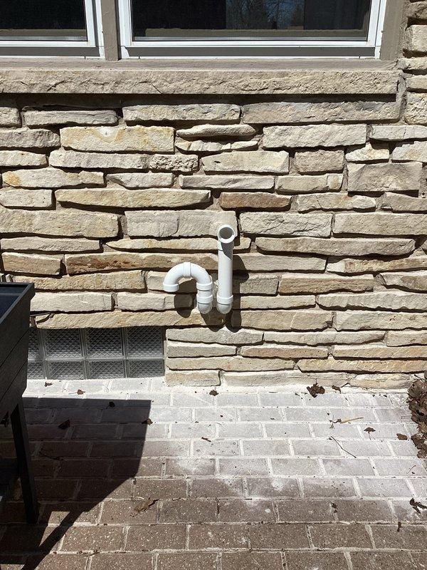 Completed furnace installation at residential property including full system setup and venting configuration. Installed new high-efficiency furnace unit with proper condensate drainage system, routed white PVC exhaust and intake piping through exterior stone veneer wall using appropriate penetration methods and weatherproofing. Mounted control unit near floor level with electrical connections and yellow gas line installation, ensuring all components meet code requirements for safe operation.