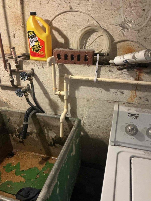 Completed installation of a comprehensive water treatment system in basement utility area, including a black water softener tank and Capital brand water filtration system with digital control head. Installed and connected white PVC piping configuration with shut-off valves, integrated copper supply lines to existing plumbing infrastructure, and established proper drainage connections using flexible corrugated hose. Mounted control components to concrete block wall, completed all electrical connections between units, verified proper system operation, and provided documentation for homeowner reference.