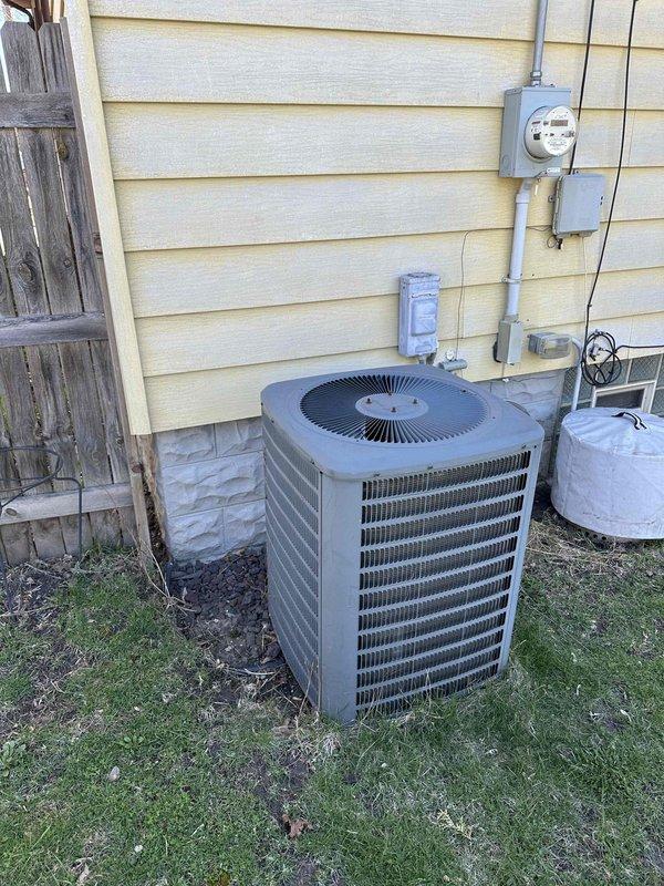 Conducted comprehensive assessment of existing HVAC system for complete replacement estimate. Evaluated outdoor condensing unit positioned on exterior foundation, noting current configuration with electrical disconnect, meter, and associated conduit routing on building exterior. Inspected basement mechanical room containing existing Carrier furnace and ductwork infrastructure, including horizontal trunk line and branch distribution system. Identified location requirements for additional return air register to improve system airflow and balance. Documented equipment specifications, electrical service capacity, condensate drainage pathways, and existing duct layout to determine replacement system requirements and installation scope.