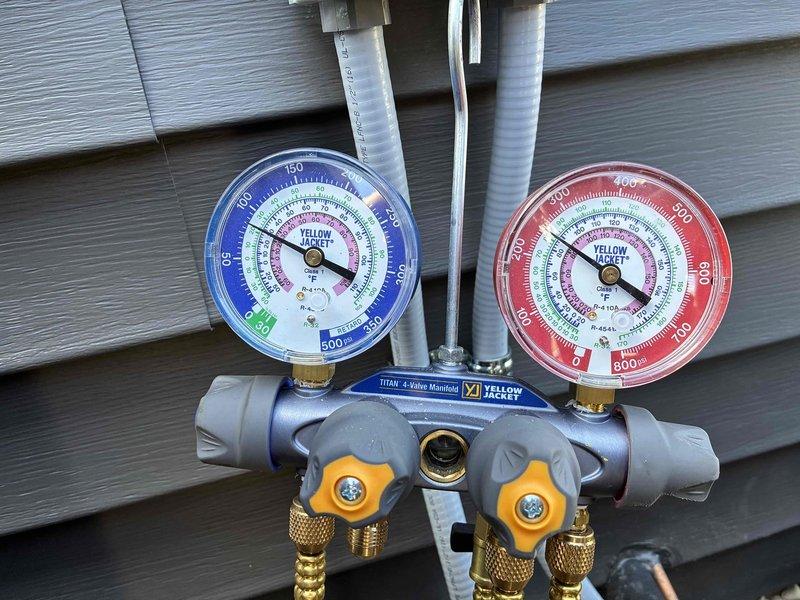 Performed warranty inspection and system diagnostics on recently installed HVAC unit. Connected Yellow Jacket Titan 4-valve manifold gauge set to verify refrigerant pressures and system performance, confirming proper charge levels and operational parameters for R-410A refrigerant system. All pressure readings were within manufacturer specifications, indicating successful installation and proper system function.