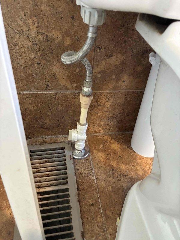 Completed comprehensive plumbing inspection of residential bathroom toilet system. Examined water supply line connections, flush valve assembly, and internal tank components, documenting discolored water indicating mineral deposits and hard water conditions requiring attention. Assessed floor-mounted plumbing fixtures, supply line integrity, and overall system functionality, noting aging components with mineral staining throughout tank interior.