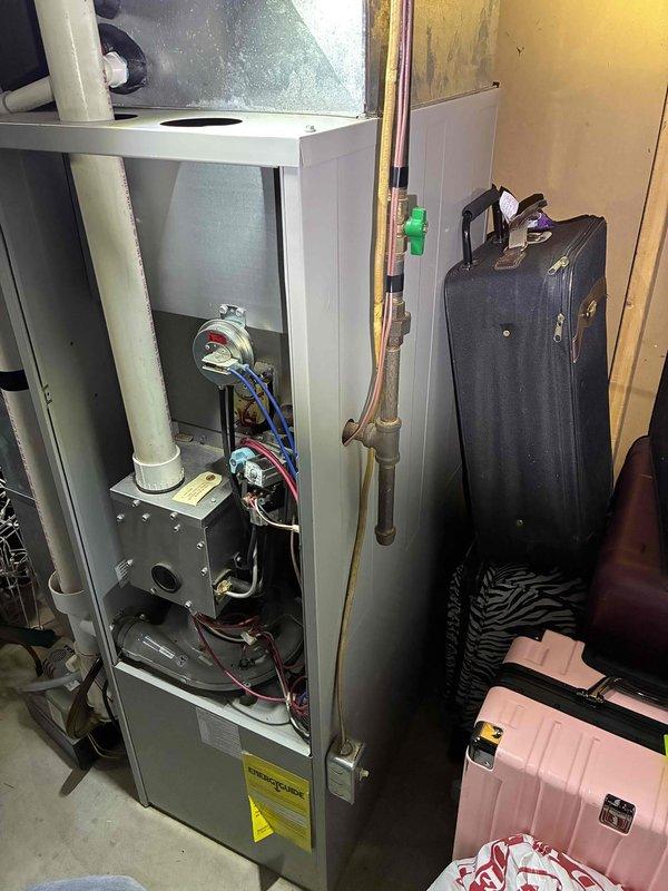Completed comprehensive estimate for full HVAC system replacement including gas furnace and outdoor condensing unit. Evaluated existing basement-installed furnace with exposed burner assembly and outdoor air conditioner positioned on concrete pad against stone foundation exterior. Assessed current system configuration including refrigerant line routing, electrical disconnect placement, PVC venting, and equipment accessibility for replacement planning.