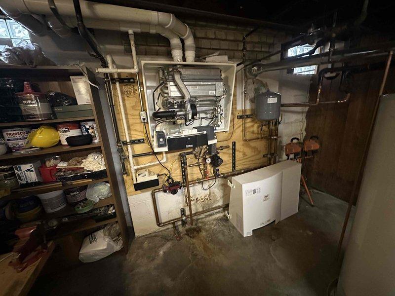 Conducted comprehensive assessment of basement mechanical room boiler system and associated HVAC components. Documented existing equipment configuration including wall-mounted heating units, copper and PVC piping networks, control boxes, expansion tank, and ventilation ductwork. Evaluated system layout, pipe connections with black valve handles, and overall mechanical infrastructure to provide accurate estimate for boiler replacement or upgrade requirements.