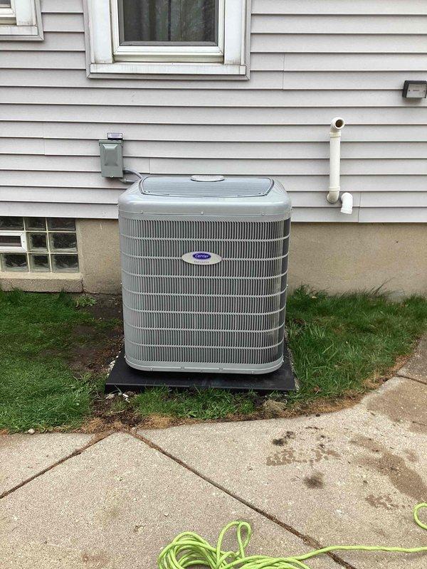 Completed installation of new Pureon air conditioning system including outdoor condenser unit and evaporator coil. Mounted condenser on composite pad adjacent to exterior wall, established refrigerant line connections with proper insulation, installed electrical disconnect box, and routed PVC condensate drain line vertically along siding. System tested and verified operational with all components functioning within manufacturer specifications.
