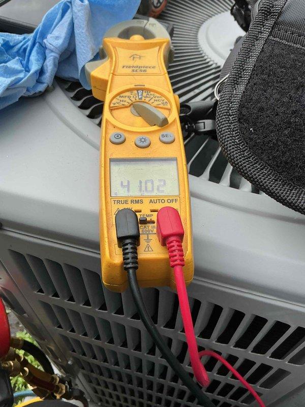 Completed routine maintenance on residential outdoor air conditioning condenser unit. Performed system diagnostics using digital clamp meter, recording electrical readings of 4.103 amps to verify proper compressor operation and system performance. Unit found in good operating condition with all components functioning within normal parameters.