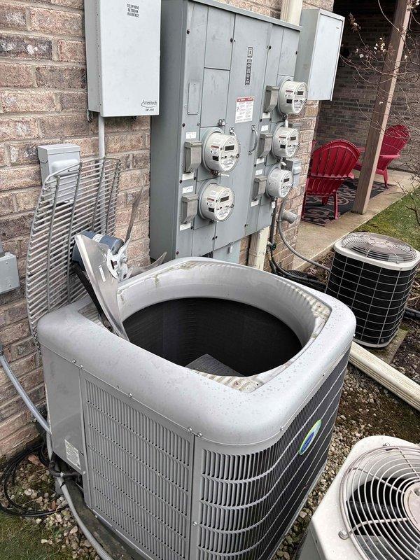 Completed comprehensive HVAC tune-up on outdoor heat pump unit. Removed top cover to access internal components, inspected compressor cavity, condensate drain pan, and refrigerant lines for proper operation. Verified electrical connections, tested control wiring and valve assembly, and confirmed all mechanical components are functioning within normal parameters.
