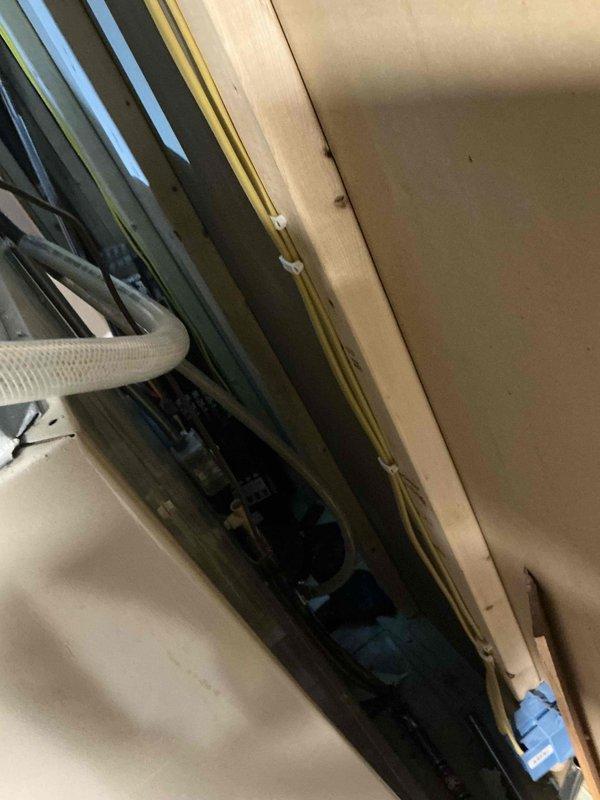 Completed comprehensive HVAC system evaluation for equipment replacement estimate. Documented existing air handler unit installed in attic space with dark green metal casing and assessed heating system components including dual expansion tanks, internal piping, valves, and control interfaces housed in white cabinet enclosure. Photographed current equipment configuration, mounting systems, ductwork connections, and mechanical components to provide detailed replacement specifications and system upgrade recommendations.