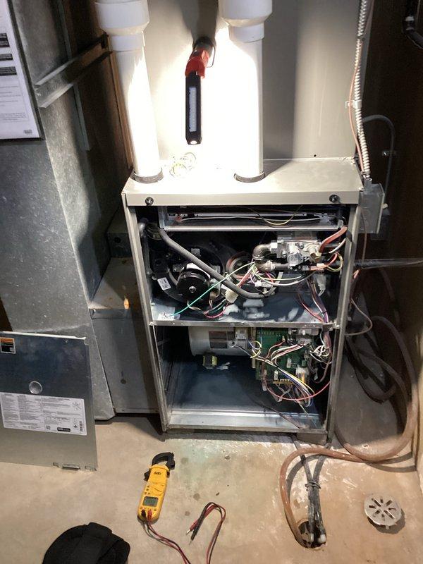 Performed comprehensive HVAC tune-up on residential furnace system. Conducted thorough inspection of internal components including blower motor, heat exchanger, ignition system, and control board. Removed front access panels to access both upper and lower compartments, tested electrical connections and circuitry using multimeter to verify proper voltage and amperage readings. Inspected PVC intake and exhaust vent pipes for proper installation and clearance. Examined ductwork connections and insulation throughout basement area, verified all mechanical linkages and wiring harnesses were secure and functioning correctly. All systems tested and operating within manufacturer specifications upon completion.