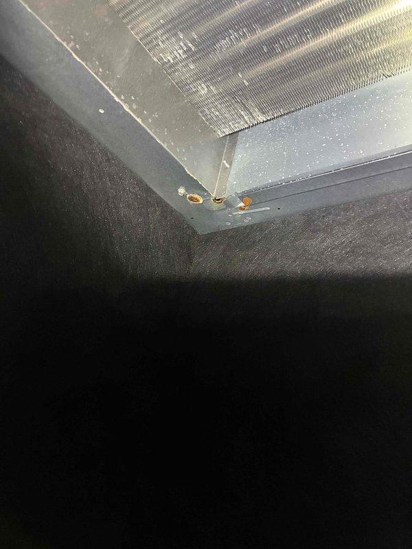 Performed warranty inspection and leveling service on HVAC cooling unit. Examined evaporator coil assembly and verified heat exchanger fins were clean and free of debris. Noted condensation present on metal housing, indicating proper system operation. Checked unit level using precision spirit level tool and confirmed proper horizontal alignment of equipment for optimal drainage and performance. All components inspected showed normal operating condition with no defects requiring correction under warranty coverage.