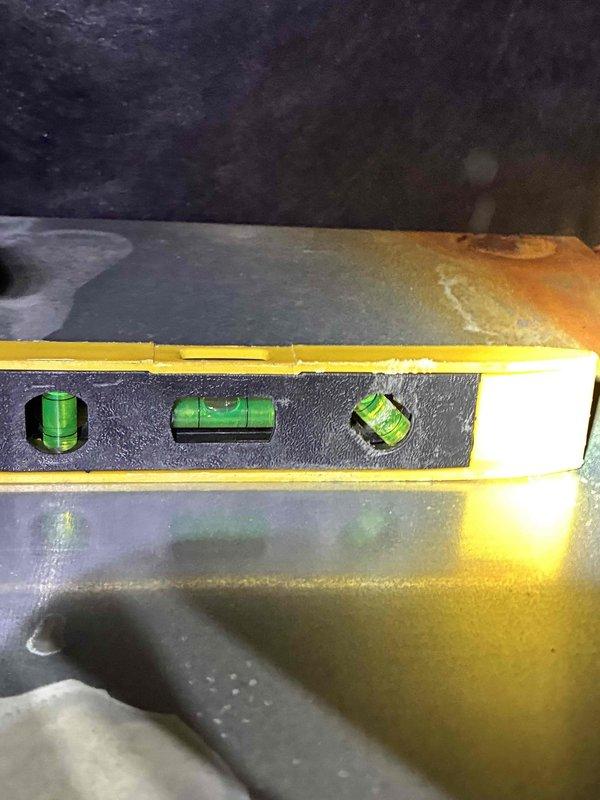 Performed warranty inspection and leveling service on HVAC cooling unit. Examined evaporator coil assembly and verified heat exchanger fins were clean and free of debris. Noted condensation present on metal housing, indicating proper system operation. Checked unit level using precision spirit level tool and confirmed proper horizontal alignment of equipment for optimal drainage and performance. All components inspected showed normal operating condition with no defects requiring correction under warranty coverage.