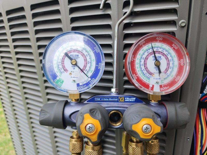 Completed installation of new air conditioning system with evaporator coil at residential property. System was set in place on concrete pad with decorative rock landscaping, refrigerant lines were run and insulated, and all electrical connections were terminated. Pressure tested system using manifold gauges, charged unit with appropriate refrigerant per manufacturer specifications, and verified proper operation of all components including the 4-valve manifold connections and service ports.