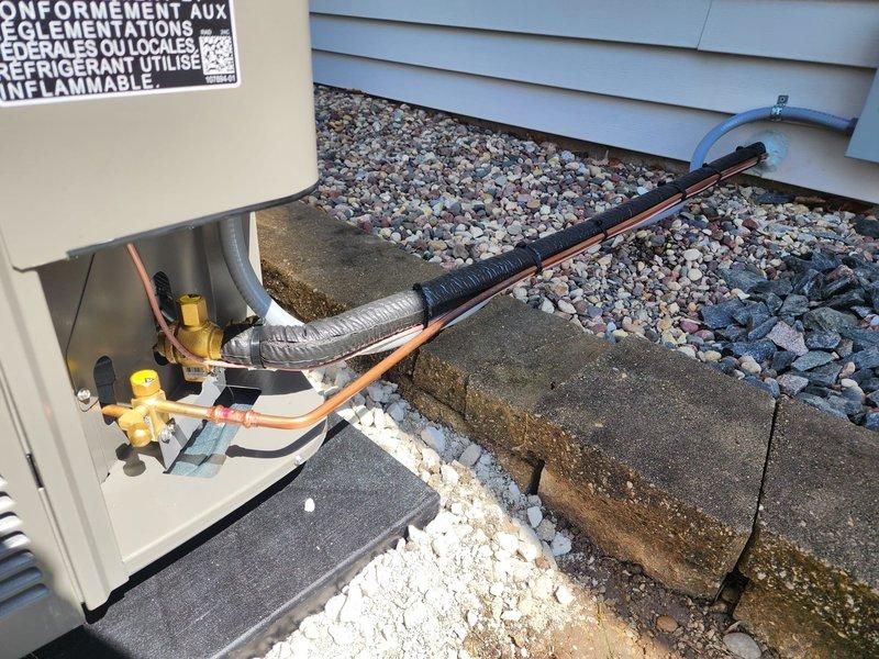 Completed installation of new air conditioning system with evaporator coil at residential property. System was set in place on concrete pad with decorative rock landscaping, refrigerant lines were run and insulated, and all electrical connections were terminated. Pressure tested system using manifold gauges, charged unit with appropriate refrigerant per manufacturer specifications, and verified proper operation of all components including the 4-valve manifold connections and service ports.