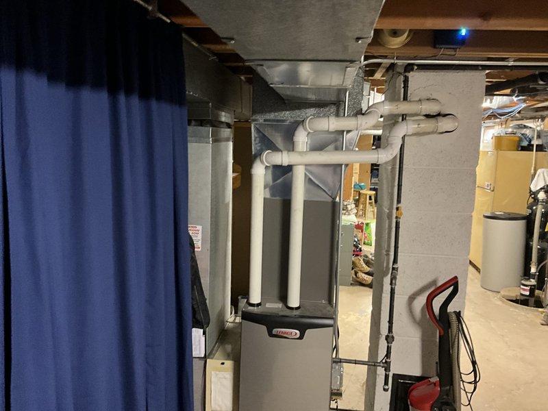Completed comprehensive HVAC system estimate for equipment replacement in residential property. Assessed existing heating and cooling unit located in basement utility area, including evaluation of current PVC condensate drainage system, ductwork configuration, and electrical connections. Documented exterior HVAC pad location and clearance requirements along decorative stone wall for potential outdoor condenser unit placement.