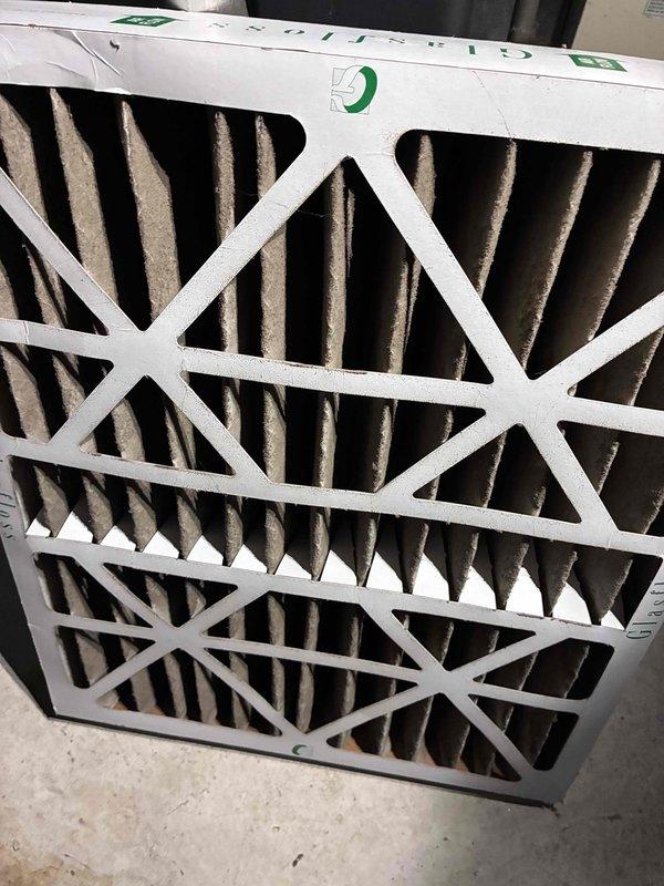 Completed routine HVAC warranty maintenance service including inspection of heating and cooling system components. Documented current system operation with thermostat displaying 74°F and verified proper temperature control functionality. Inspected air filtration system and documented heavily soiled filter media requiring replacement to maintain optimal airflow and system efficiency.