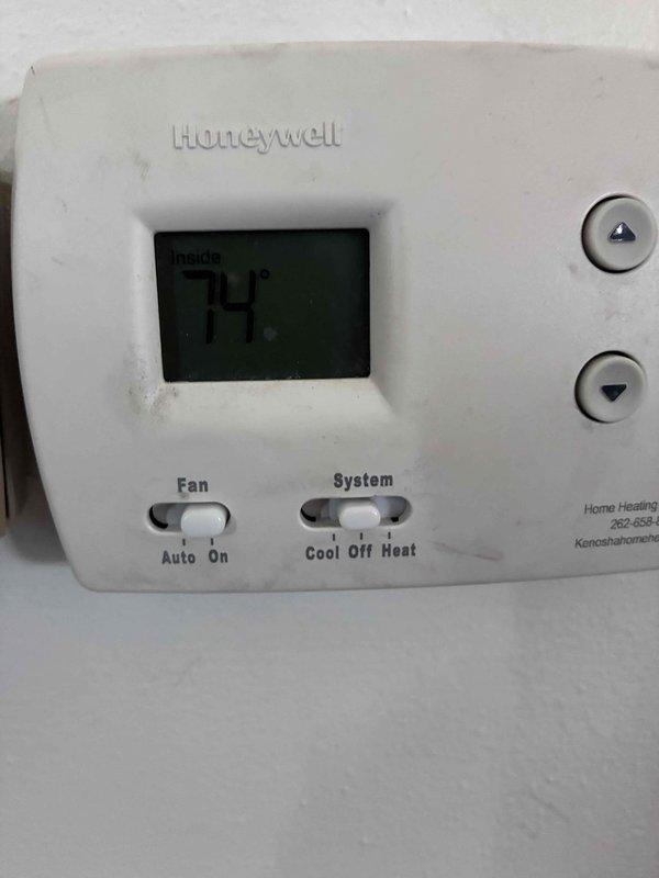 Completed routine HVAC warranty maintenance service including inspection of heating and cooling system components. Documented current system operation with thermostat displaying 74°F and verified proper temperature control functionality. Inspected air filtration system and documented heavily soiled filter media requiring replacement to maintain optimal airflow and system efficiency.